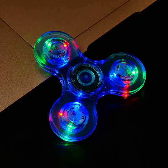 Colorful LED spinner on a dark surface with a brown box in the background
