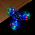 Colorful LED spinner on a dark surface with a brown box in the background